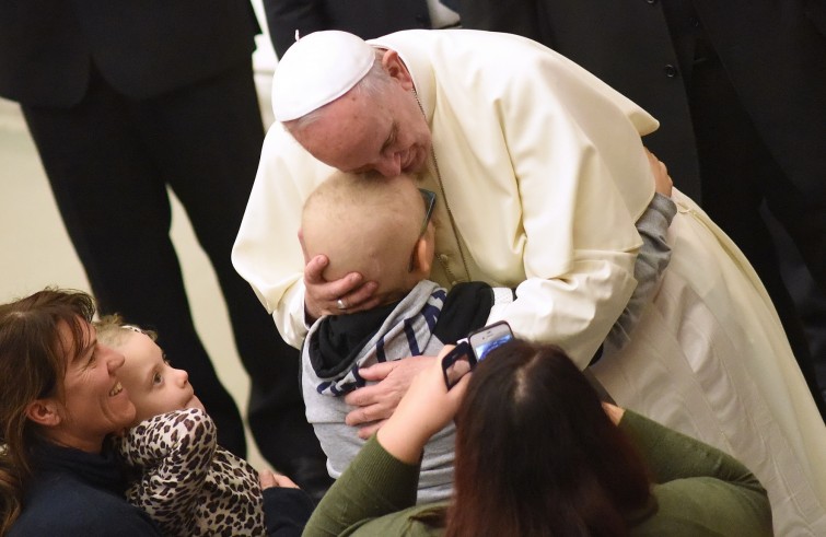 Vaticano, 13 gennaio 2016: Udienza generale di Papa Francesco in Aula Paolo VI - Papa Francesco abbraccia un bambino tra gli ammalati