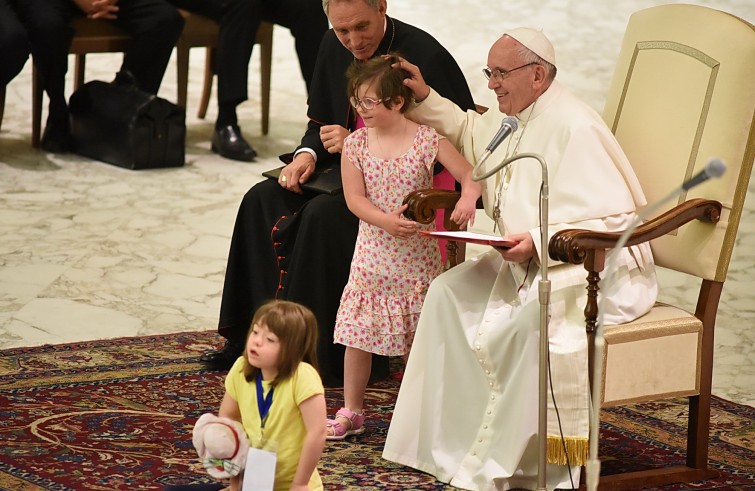 Aula Paolo VI, 11 gennaio 2016: convegno Cei per il 25° del Settore per la catechesi delle persone disabili - Papa Francesco saluta una bambina down  dalla poltrona