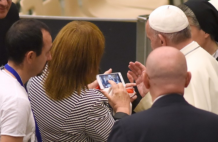 Aula Paolo VI, 11 gennaio 2016: convegno Cei per il 25° del Settore per la catechesi delle persone disabili - Papa Francesco benedice la foto di una famiglia in un cellulare