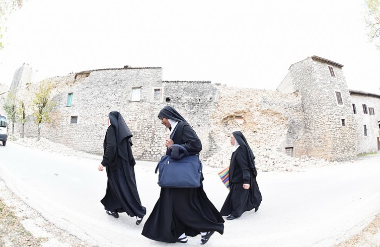 Norcia, 2 novembre 2016: terremoto - suore camminano davanti a muro crollato