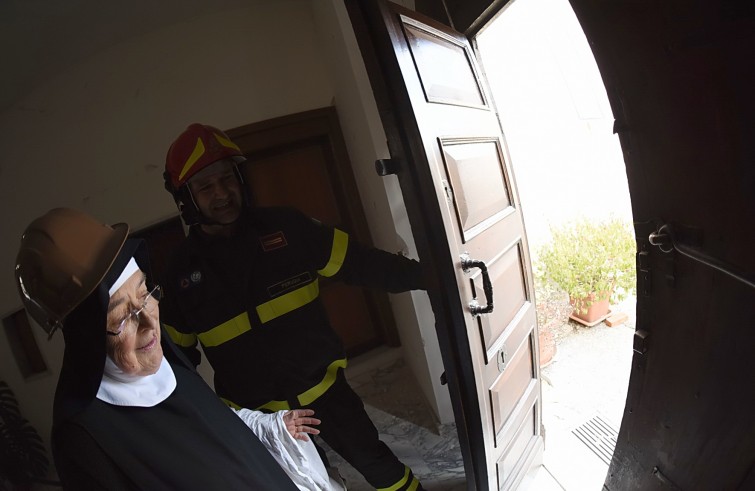 Norcia, 2 novembre 2016: terremoto - suora con vigile del fuoco